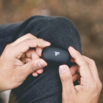 Hands holding wireless earbuds
